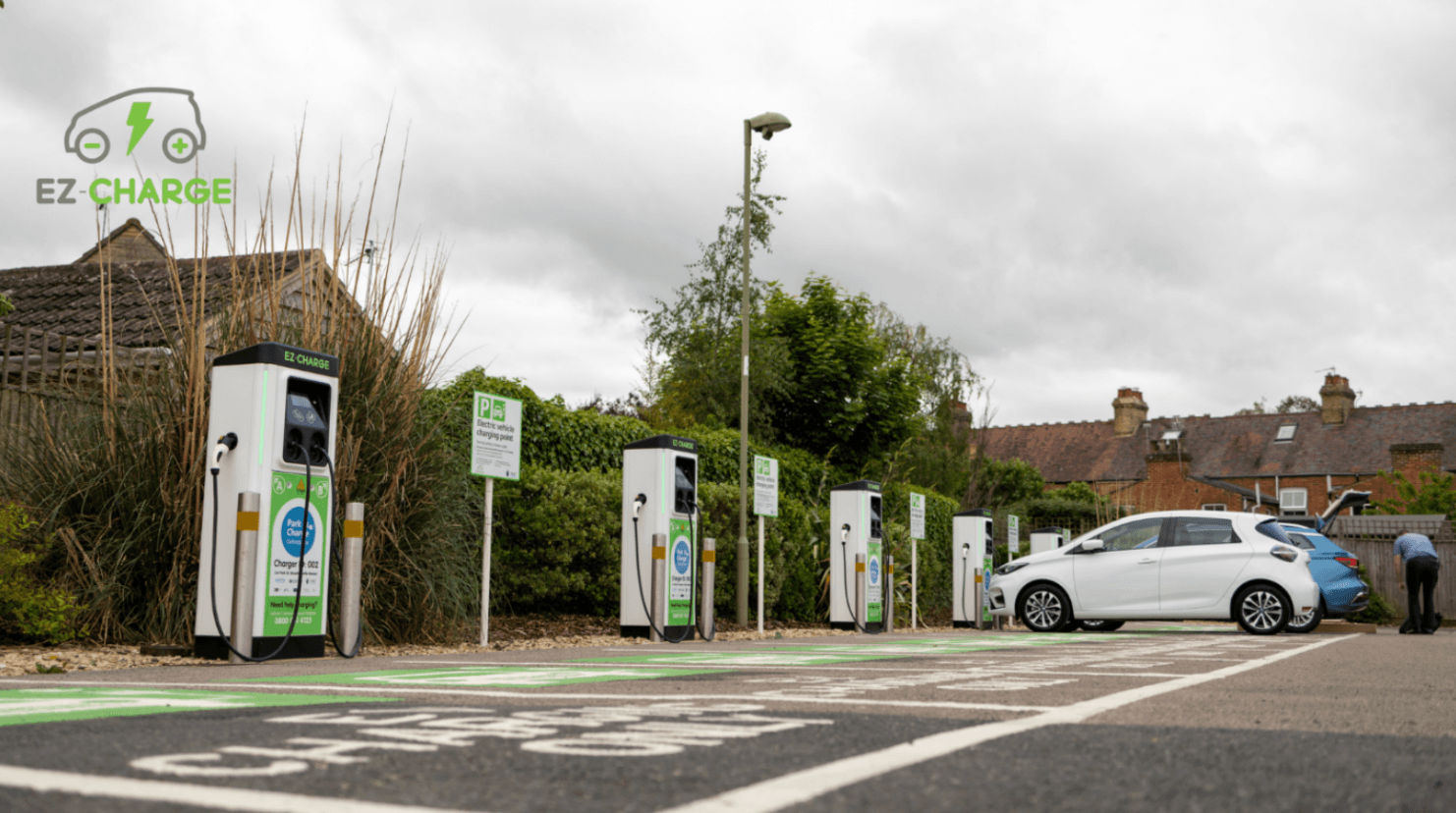 A white car parked next to a charging station