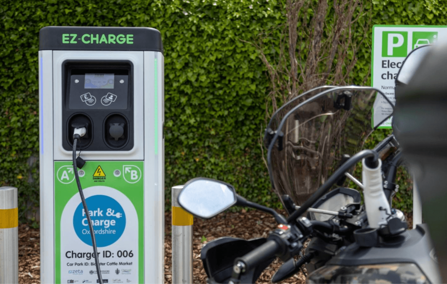 A motorbike parked next to a charging station