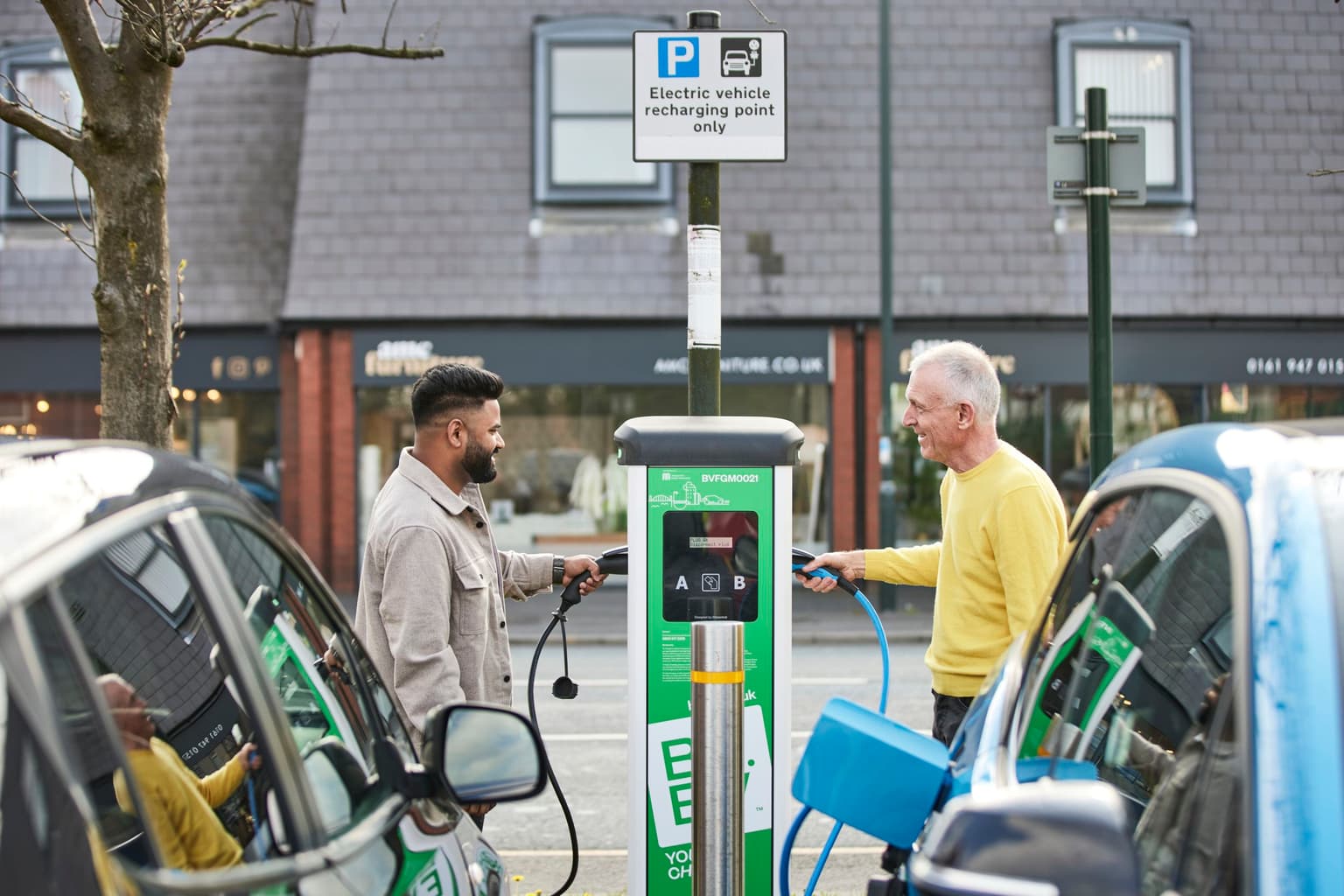 Two men using a Be.EV charging point at the same time