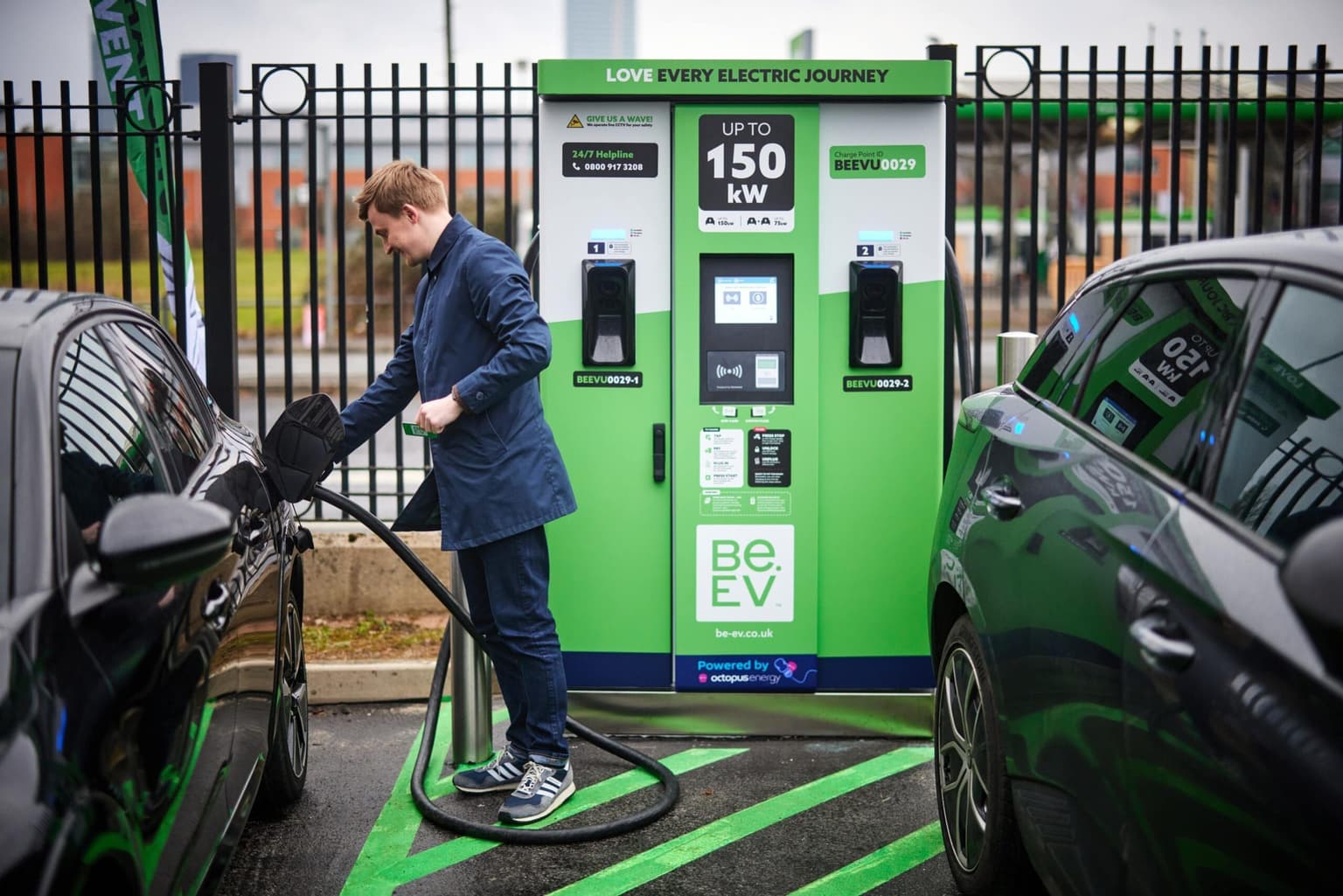A man plugging in a charging cable to a Be.EV electric vehicle charge point