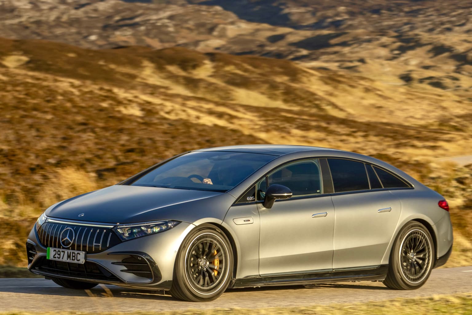 Un'auto elettrica Mercedes EQS grigia, sullo sfondo di un paesaggio montano