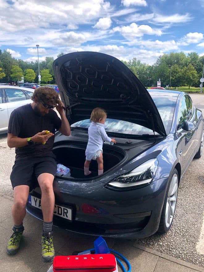 A Tesla with its front boot open with Jordan Brompton family's inside. Une Tesla avec son coffre avant ouvert avec la famille Jordan Brompton à l'intérieur. Ein Tesla mit geöffneter Heckklappe und der Familie Jordan Brompton darin. Um Tesla com a bagageira aberta com a família Jordan Brompton lá dentro. Una Tesla con il bagagliaio anteriore aperto, con all'interno la famiglia di Jordan Brompton. Un Tesla con el maletero delantero abierto con la familia Jordan Brompton en su interior.