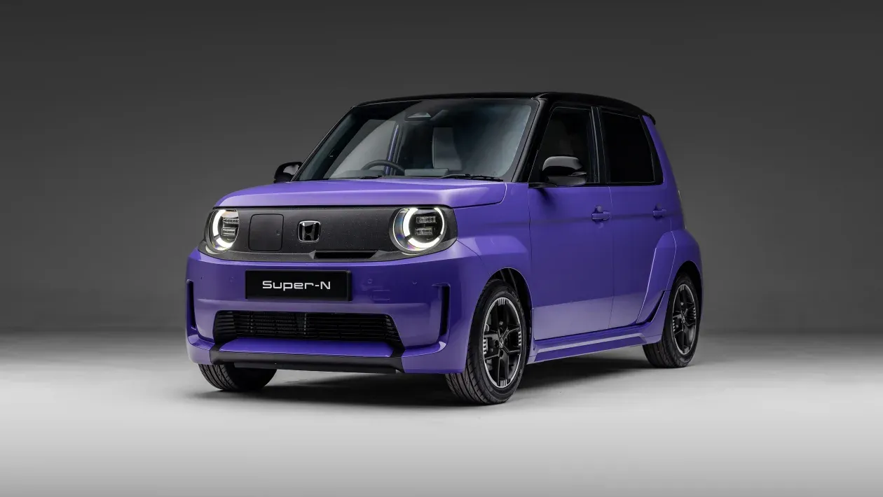 Ein kompaktes, futuristisches violettes Auto mit schwarzem Frontgrill, präsentiert in einer schwach beleuchteten Umgebung.