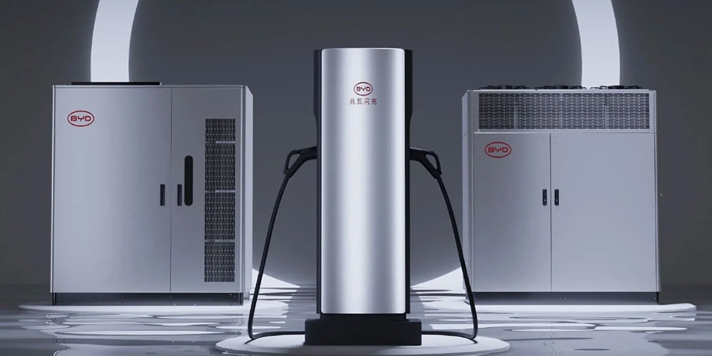 Estación de carga futurista con un elegante diseño plateado, flanqueada por dos unidades industriales, todas con el logotipo de BYD en un entorno moderno.