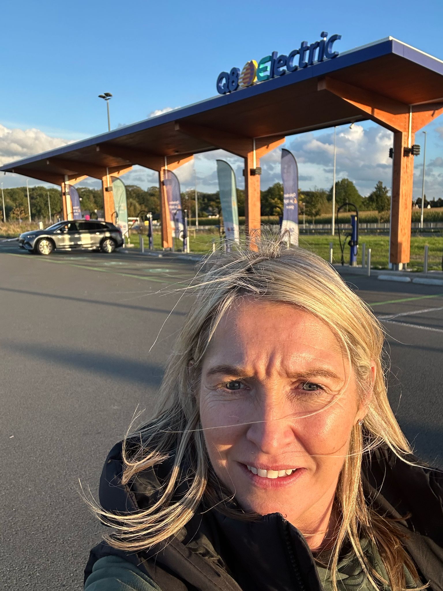Amanda Armitage in front of charging station. Amanda Armitage frente a la estación de carga. Amanda Armitage davanti alla stazione di ricarica. Amanda Armitage em frente à estação de carregamento. Amanda Armitage vor der Ladestation. Amanda Armitage devant la borne de recharge.