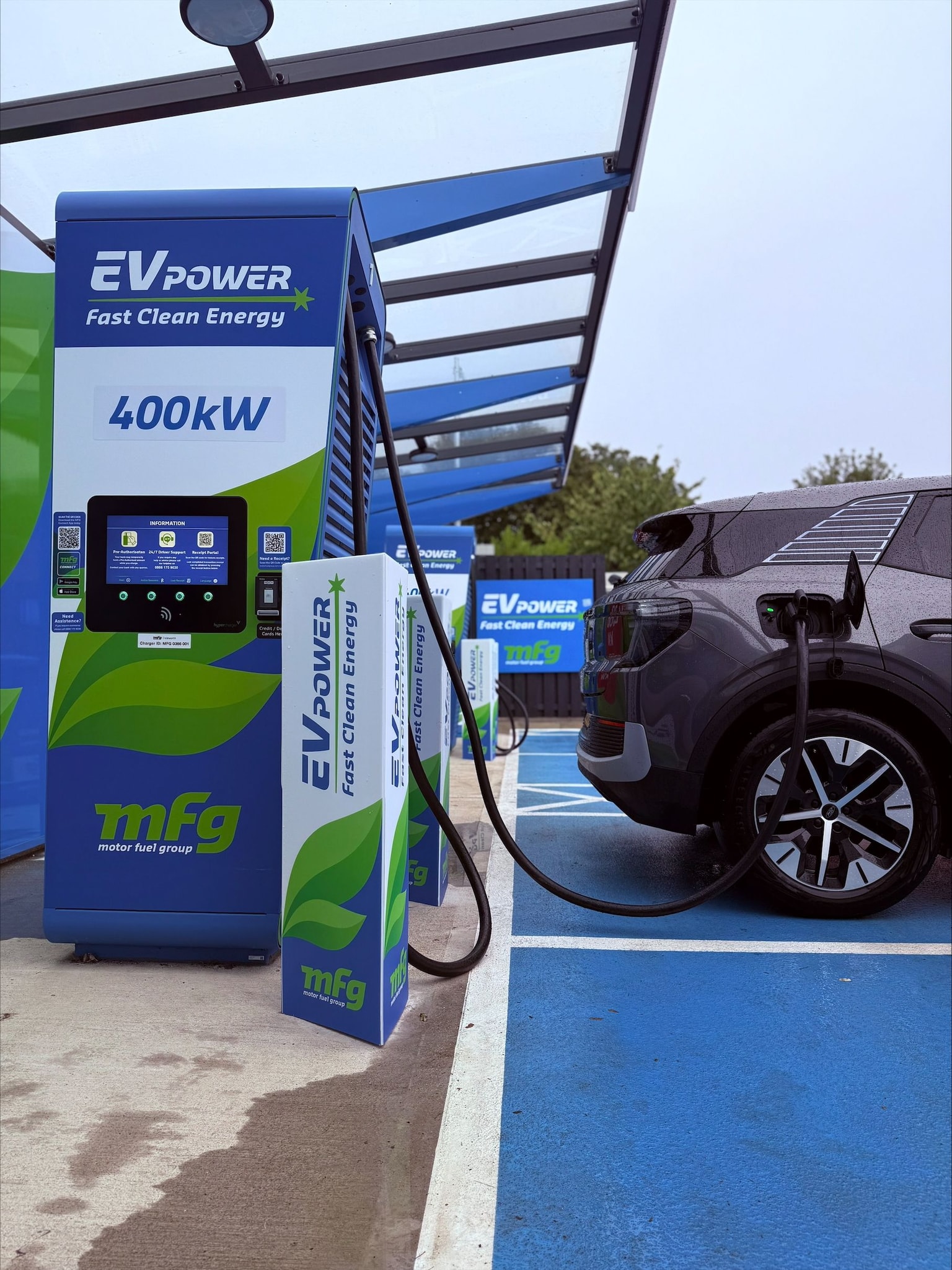 Electric vehicle charging at a station with "EV Power" branding, labeled "400kW," in a covered parking area.