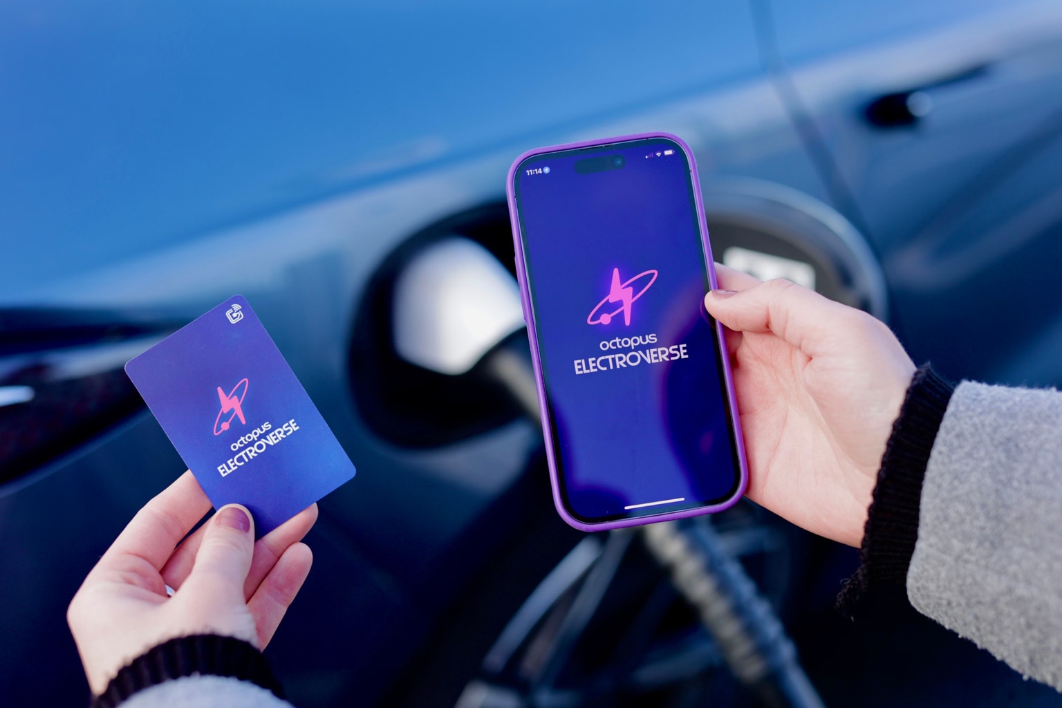 Photo montrant les applications Electrocard et Electroverse ouvertes sur un téléphone, tenu devant un véhicule électrique branché