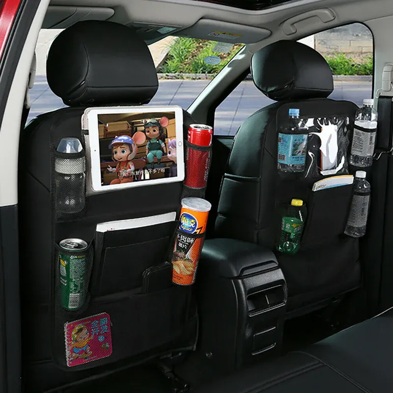 Organizadores para el asiento trasero del coche con bebidas variadas, aperitivos y una tableta con un programa animado. Interior rojo visible.