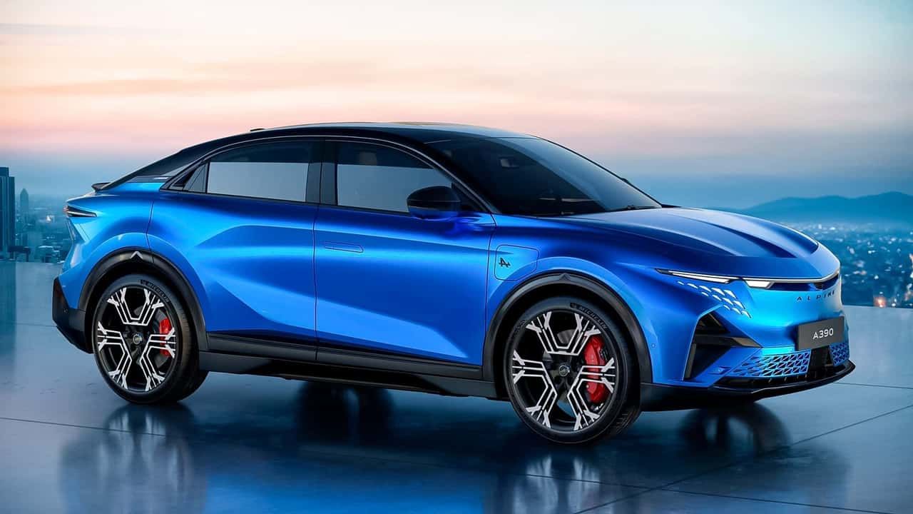 Ein Foto eines blauen Alpine A390 Concept, geparkt auf einer Plattform mit Blick auf eine bergige Kulisse bei Sonnenuntergang.