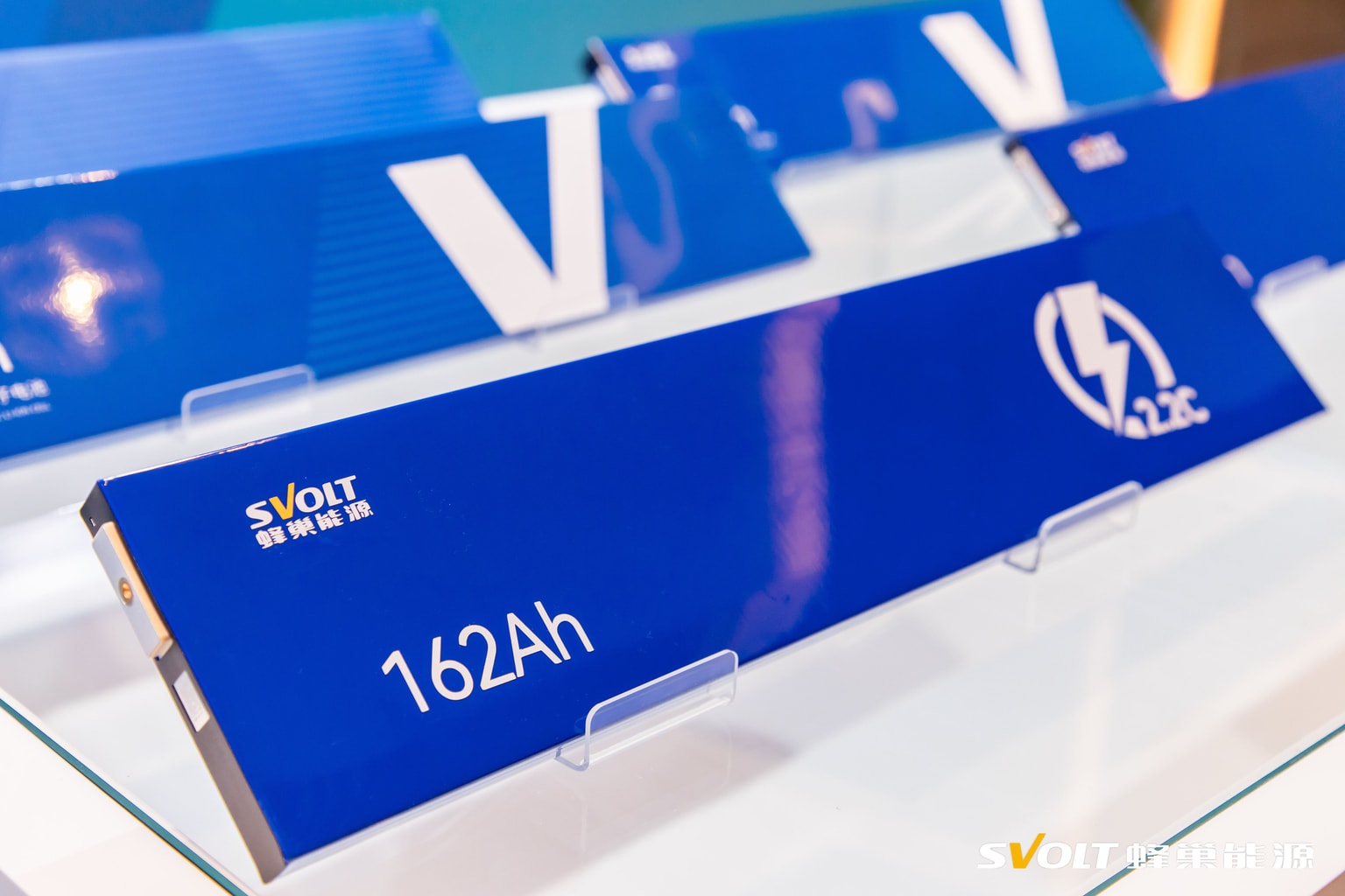 Blue battery module displayed on a stand, featuring "162Ah" and a lightning bolt icon, with company branding in the corner.