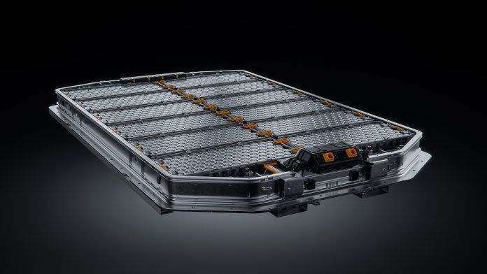 Un paquete de baterías para vehículos eléctricos, elegante y rectangular, con celdas y conectores visibles, sobre un fondo degradado oscuro.