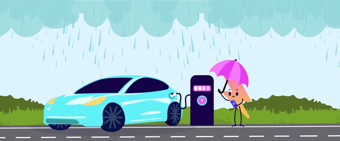 Una persona con un ombrello ricarica un'auto elettrica in una stazione durante la pioggia, con verdi colline sullo sfondo.